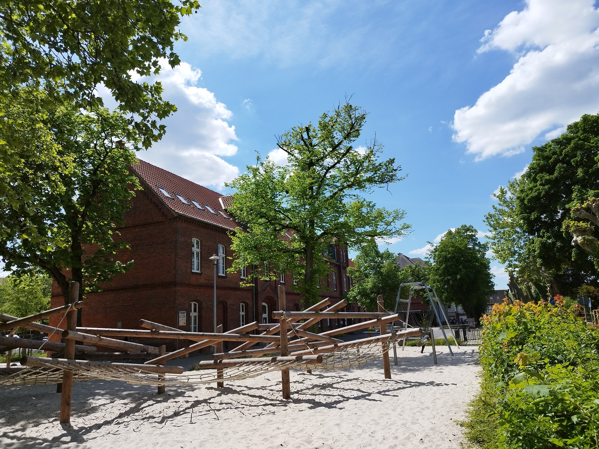 Foto: Blick über einen Spielplatz auf die Schule