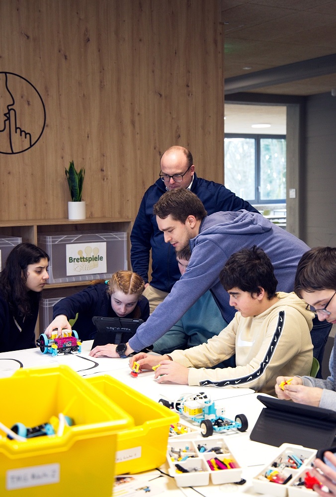 Martin Votava und Marius Trümper (l.) mit Schülern der Lego-Robotik AG der TMG