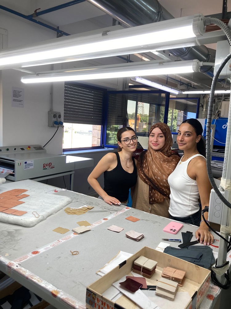 Foto: Drei junge Frauen an einer Werkbank