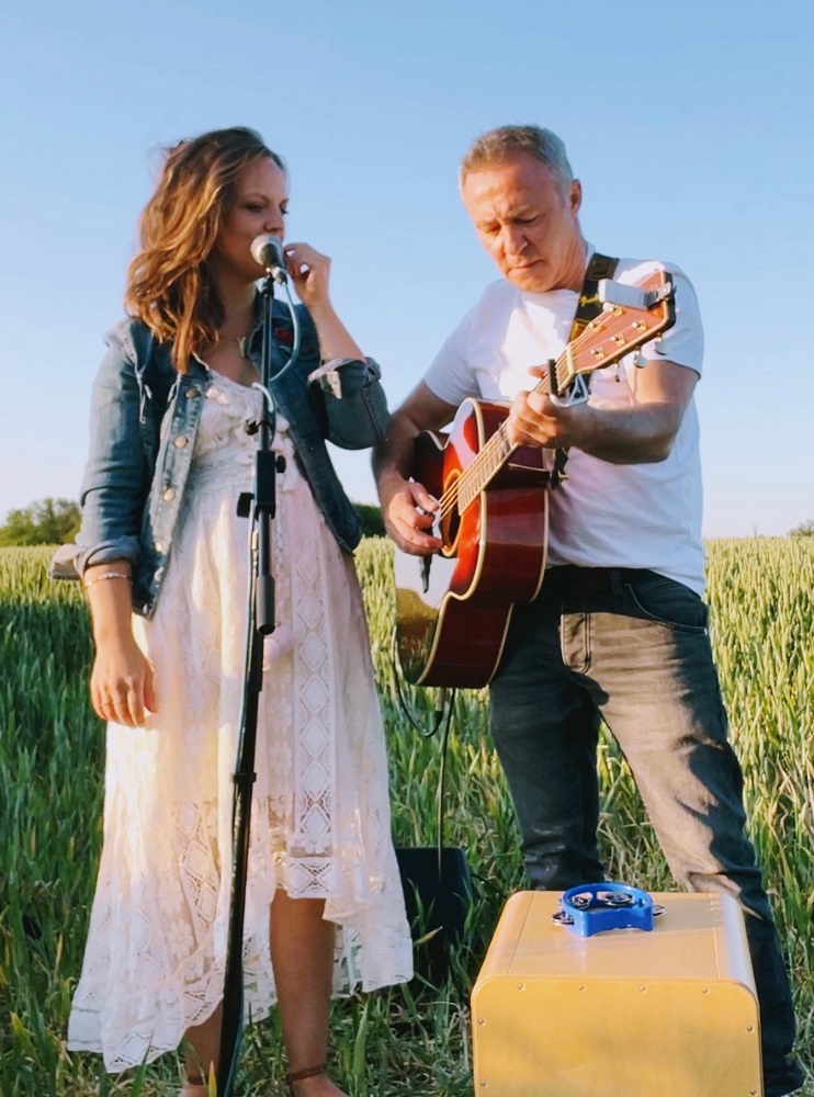 Foto: Paar mit Gitarre auf einer Wiese