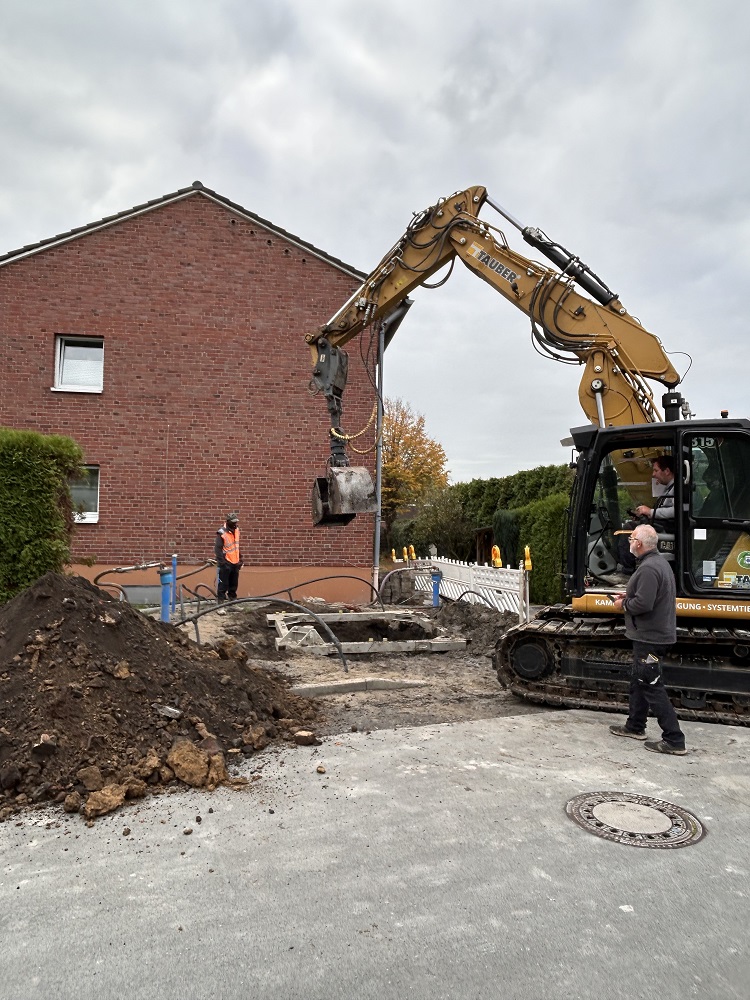 Foto: Bagger vor einem Mehrfamilienhaus