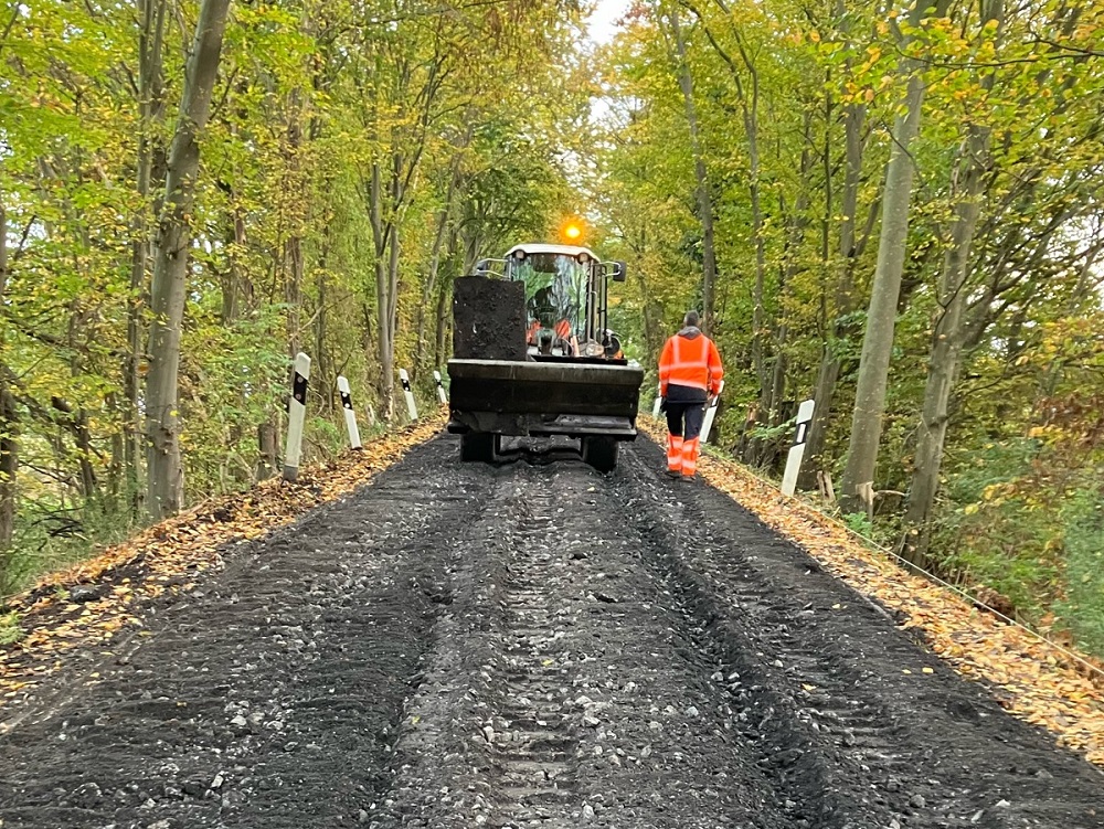 Foto: Wirtschaftsweg im Wald mit einer Baumaschine