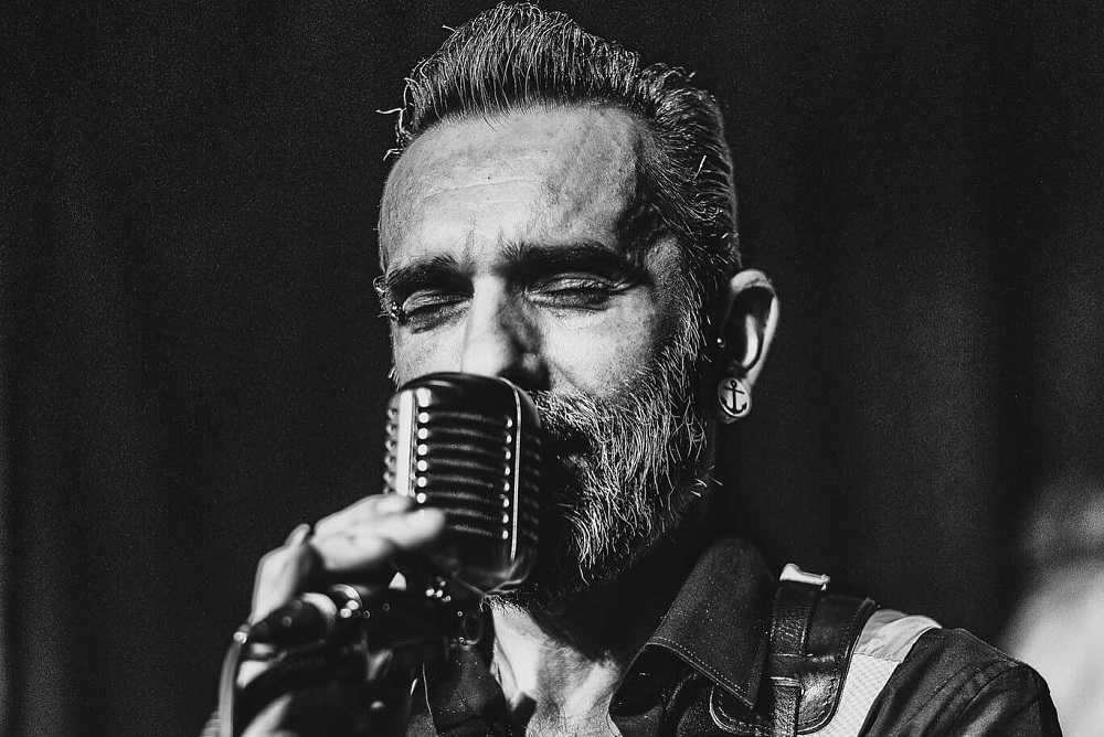 Foto: Porträt von Dimi mit einem Mikrofon