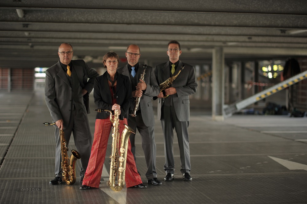 Foto: 4 Personen mit Blasinstrumenten in einer Halle