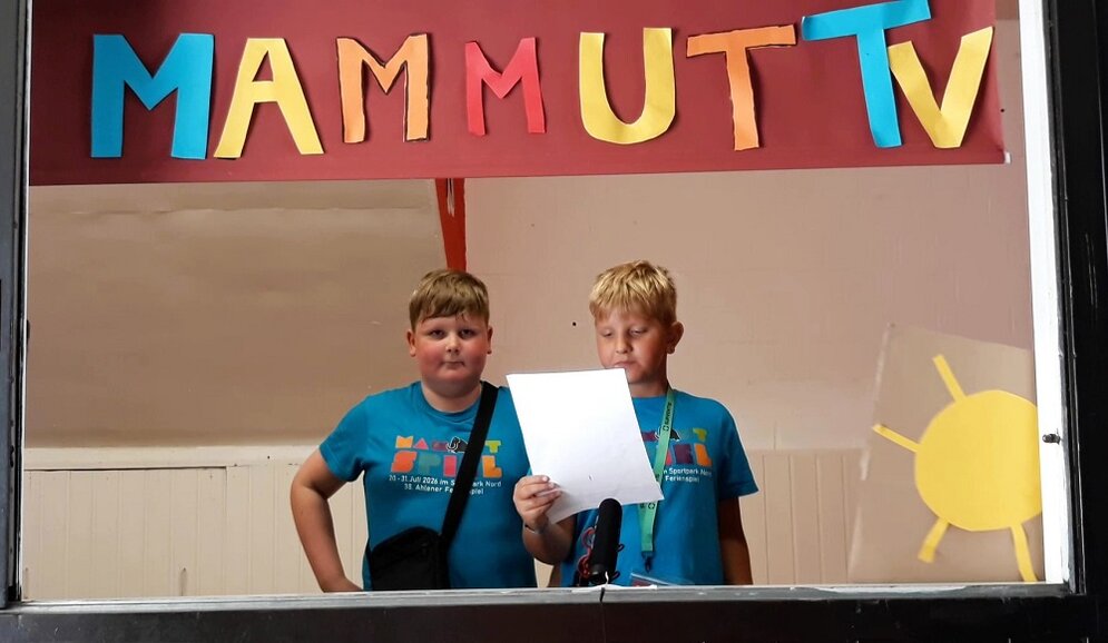 Foto: 2 Jungen unter dem Schild "Mammut-TV"