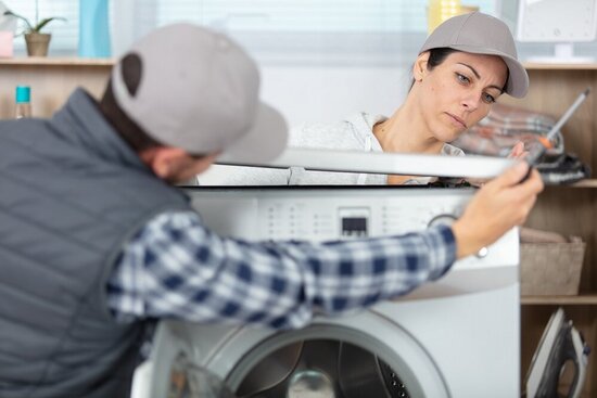 Foto: 2 Handwerker mit einer Waschmaschine