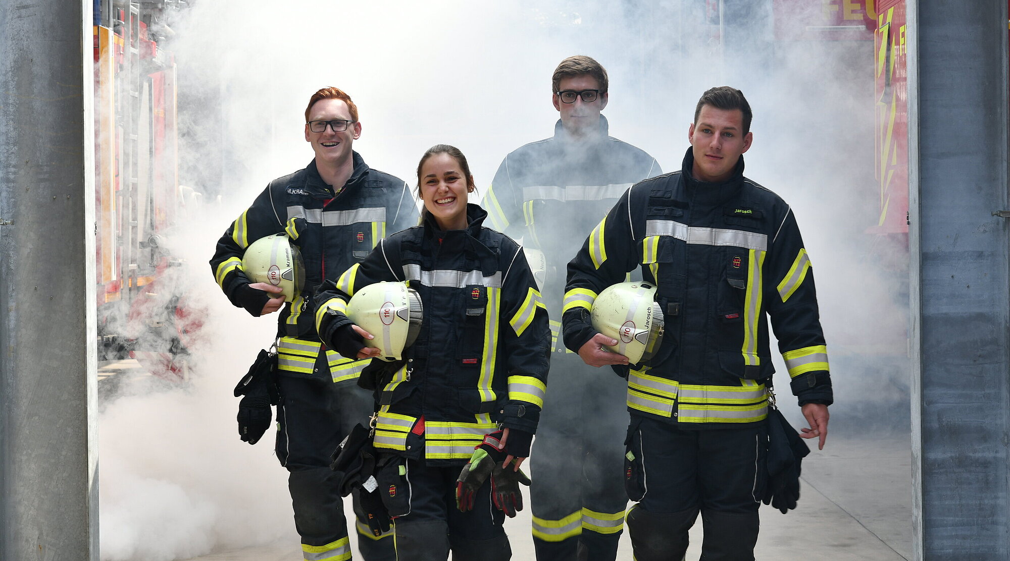 Foto: 4 Brandmeister in einer Rauchwolke
