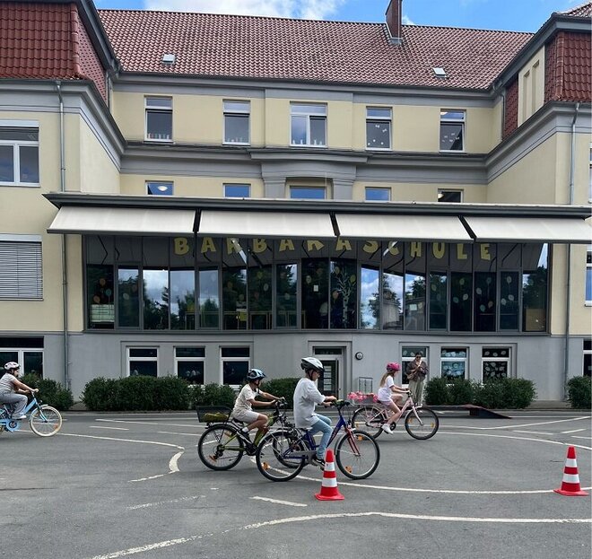 Foto: Kinder auf Fahrrädern vor der Barbaraschule