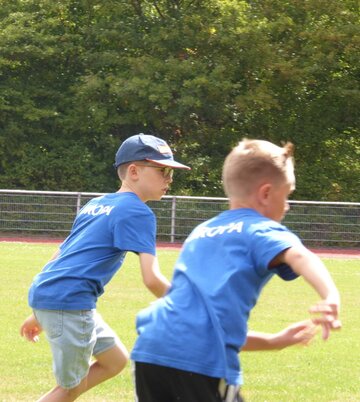 Foto: 2 Jungen laufen auf einer Wiese