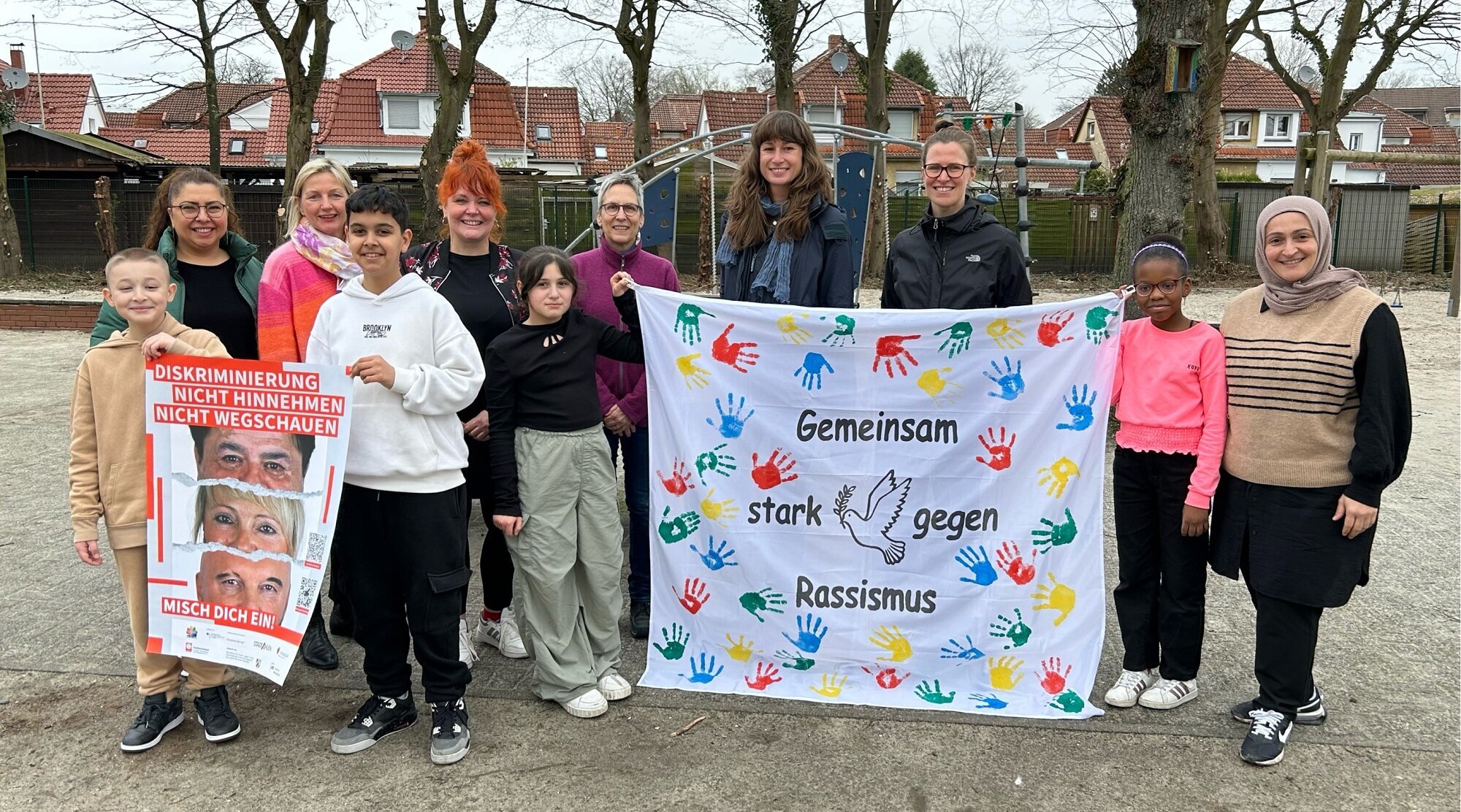 Foto: Gruppe mit einem Banner "Gemeinsam gegen Rassismus"