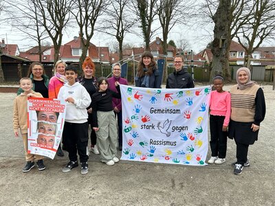 Foto: Gruppe mit einem Banner "Gemeinsam gegen Rassismus"