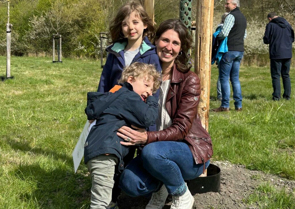 Mutter mit zwei Söhnen im Park vor Baum