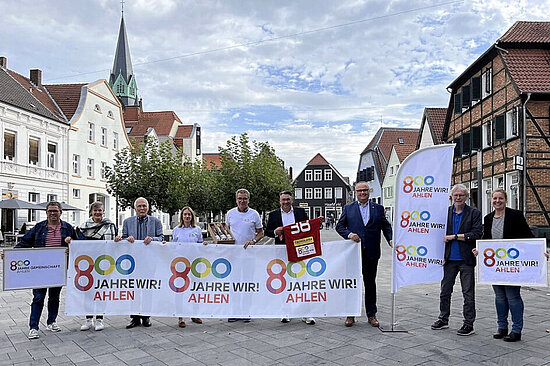 Foto: Gruppe auf dem Marktplatz mit Bannern "800 Jahre wir! Ahlen"