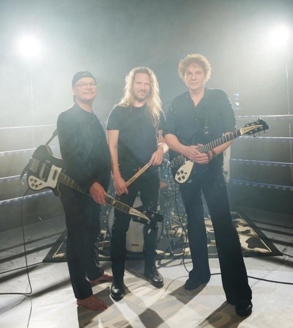 Foto: 3 Männer in schwarzer Kleidung mit Instrumenten