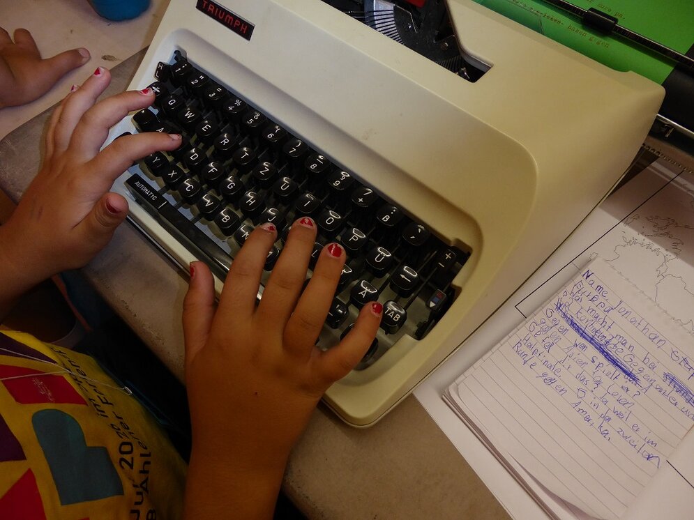 Foto: Kinderhände auf einer manuellen Schreibmaschine
