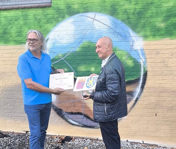 Foto: Michael Preuten übergibt einen Scheck an Jeshu Jakob