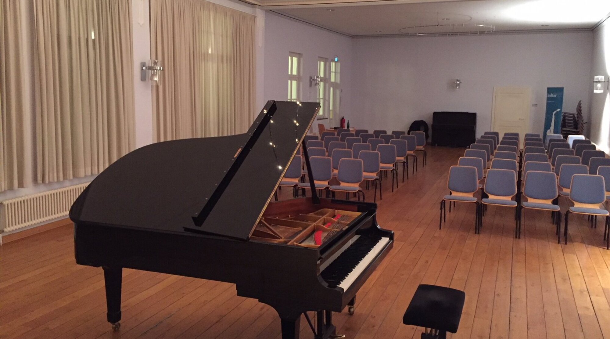 Foto: Saal Sandgathe - Blick auf ein Klavier und Bestuhlung