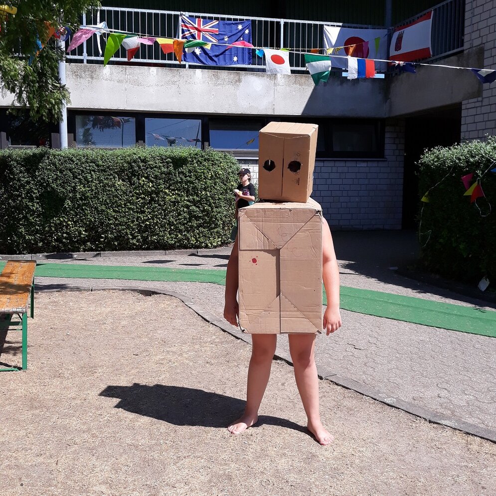 Foto: Kind als Roboter mit Kartons angezogen