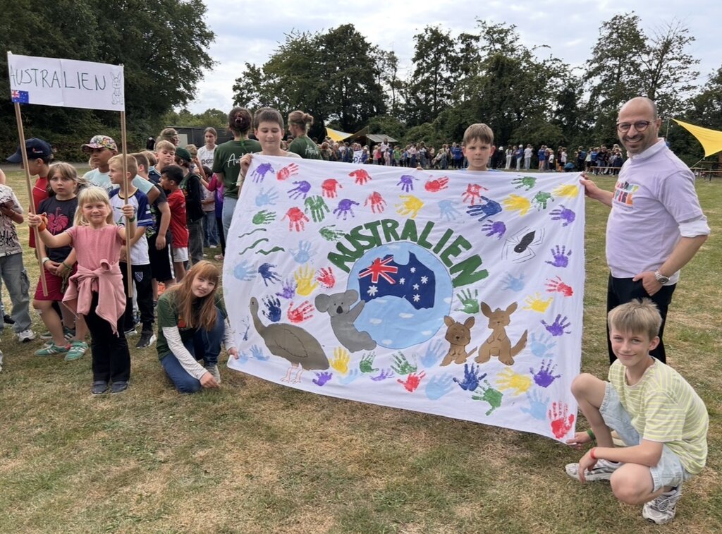 Foto: BM Harmann mit Kindern die ein Australien-Banner halten