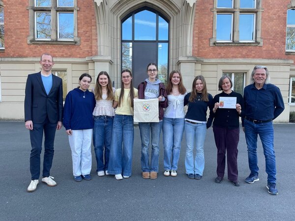 Foto: Gruppenbild auf einem Platz vor einer Eingangstür