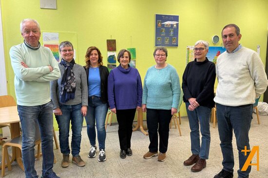 Gruppe von Menschen steht in einem Raum in einer Schule