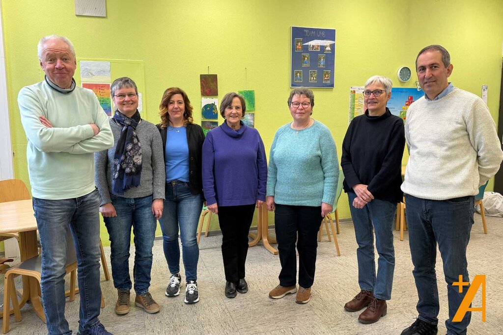 Gruppe von Menschen steht in einem Raum in einer Schule