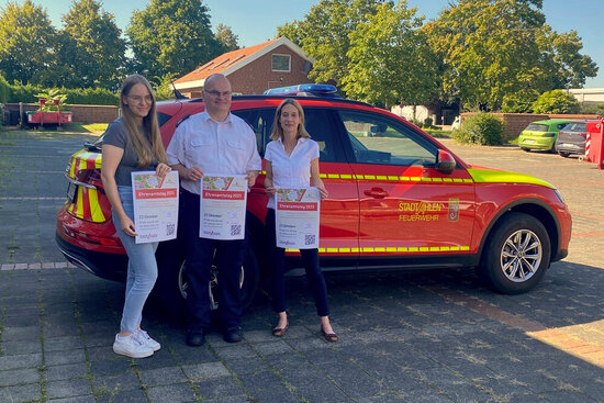 Foto: Stefanie Kosbab, Christoph Faust und Marie-Kristin Martins da Cruz vor einem Feuerwehrfahrzeug