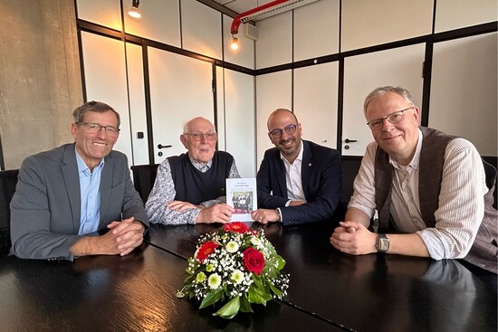 Helmut Neumann (2.v.l.) überreicht Bürgermeister Matthias Harman die erste Ausgabe seiner Lebenserinnerungen. Unterstützung bekam der 86-jährige von seinen Freunden Ludger Diekmann (l.) und Martin Frost (r.). Foto: Buchpräsentation
