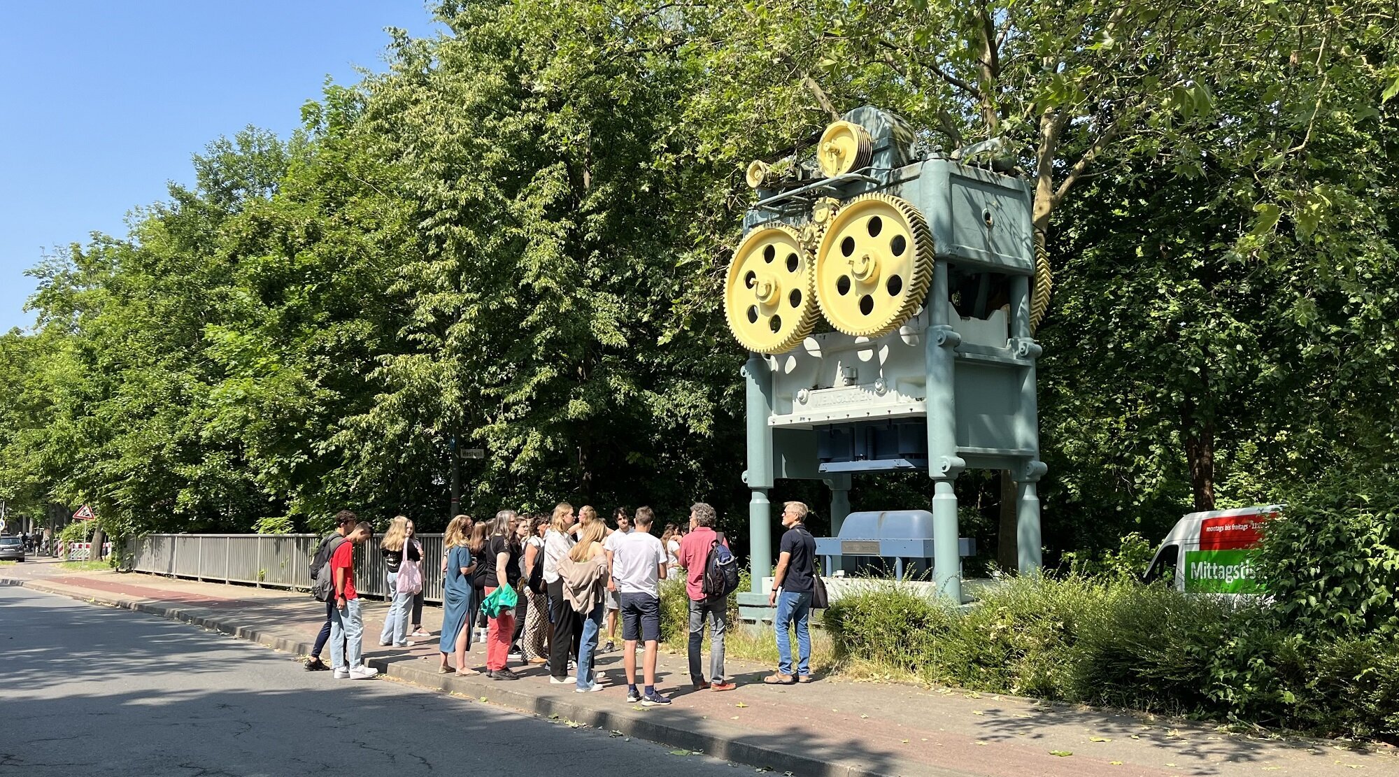 Foto: Gruppe auf einer Brücke vor einem Industriedenkmal