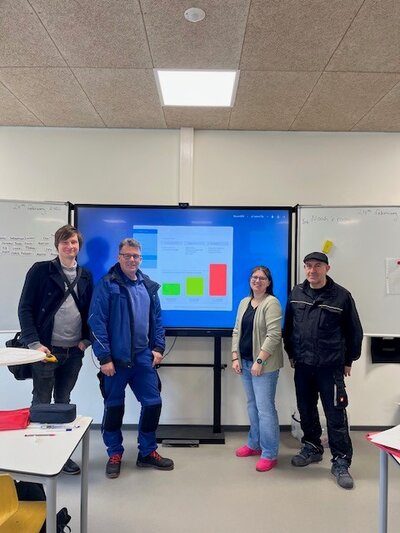 Foto: Gruppenbild vor einem Monitor