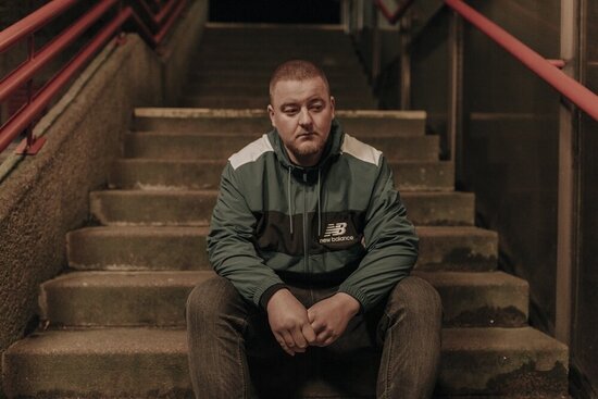 Foto: Simon Lang auf einer Treppe sitzend