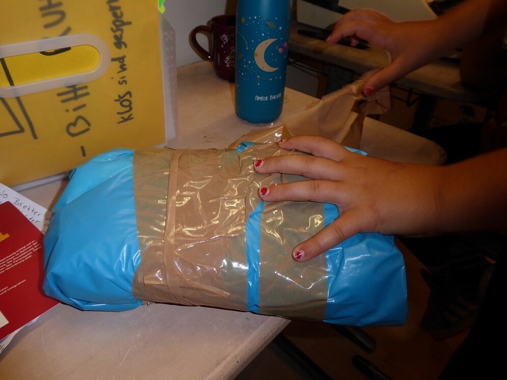Foto: Paket wird on Kinderhänden geöffnet
